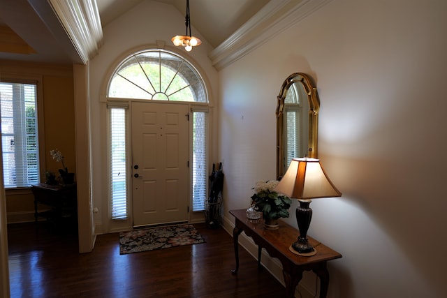 foyer entrance with a notable chandelier, crown molding, vaulted ceiling, and dark wood-style flooring