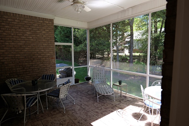 sunroom / solarium featuring a ceiling fan