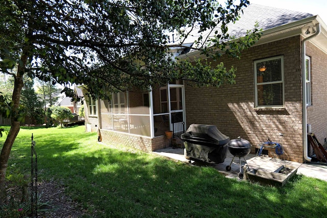 exterior space with brick siding, a lawn, and a sunroom