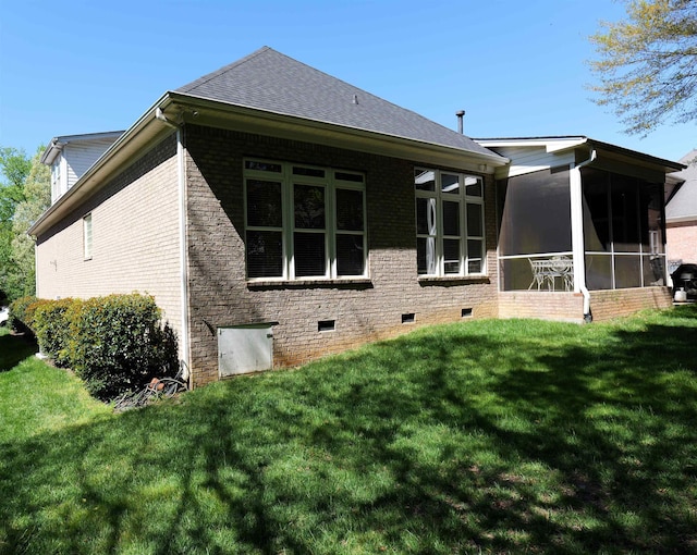 back of property with a shingled roof, a sunroom, crawl space, a yard, and brick siding