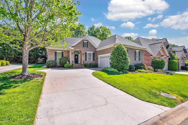 view of front of property featuring an attached garage, a front lawn, and brick siding