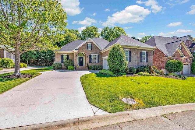 view of front of property with a front yard, concrete driveway, and brick siding