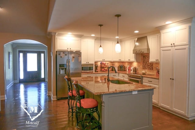 kitchen with premium range hood, a kitchen island with sink, white cabinets, dark hardwood / wood-style flooring, and stainless steel appliances