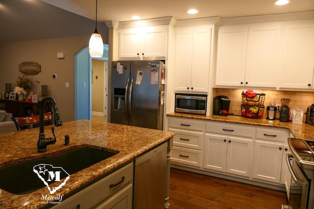 kitchen featuring decorative light fixtures, dark hardwood / wood-style floors, stainless steel appliances, sink, and stone countertops