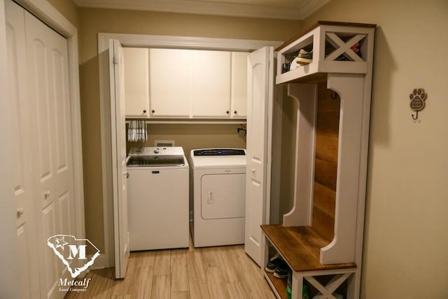 clothes washing area featuring cabinets, light hardwood / wood-style flooring, independent washer and dryer, and crown molding