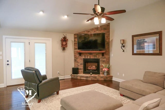 living room featuring ceiling fan, lofted ceiling, dark wood-type flooring, and a stone fireplace