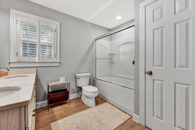 full bathroom featuring hardwood / wood-style flooring, dual bowl vanity, toilet, and enclosed tub / shower combo