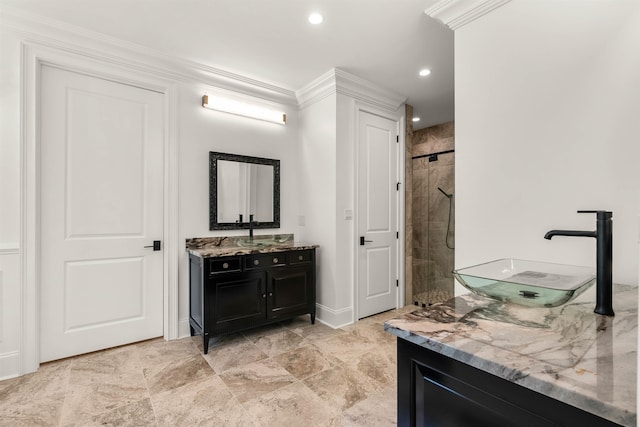 bathroom featuring ornamental molding, tiled shower, vanity, and tile floors