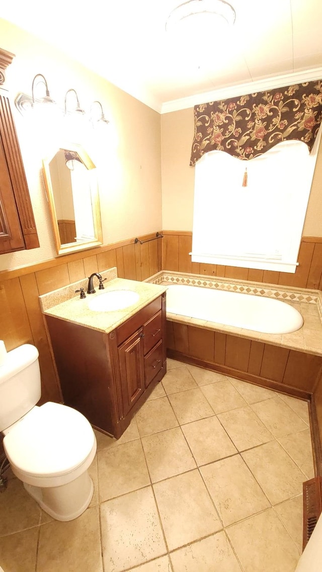 bathroom with toilet, tile floors, ornamental molding, a bathtub, and vanity