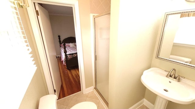 bathroom featuring sink, an enclosed shower, toilet, and tile flooring