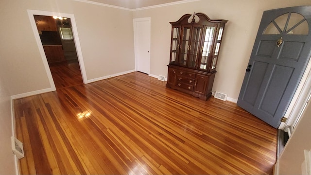 spare room with crown molding and hardwood / wood-style flooring