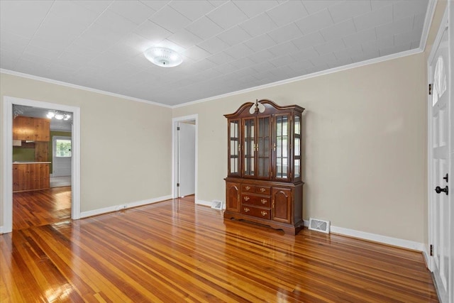 unfurnished room featuring crown molding and hardwood / wood-style flooring