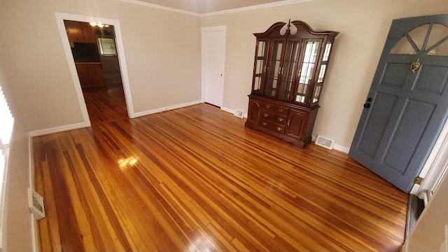 spare room featuring ornamental molding and hardwood / wood-style flooring