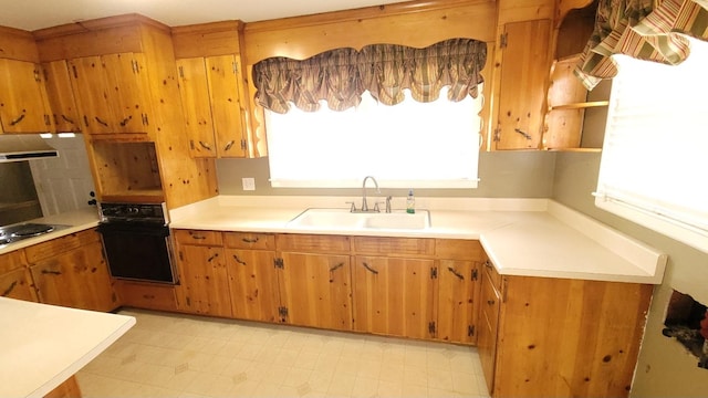 kitchen featuring sink, exhaust hood, light tile flooring, and black appliances