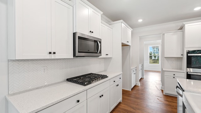 kitchen featuring light stone counters, dark hardwood / wood-style floors, white cabinets, stainless steel appliances, and crown molding