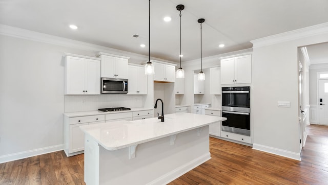 kitchen featuring a center island with sink, dark wood-type flooring, stainless steel appliances, and white cabinets