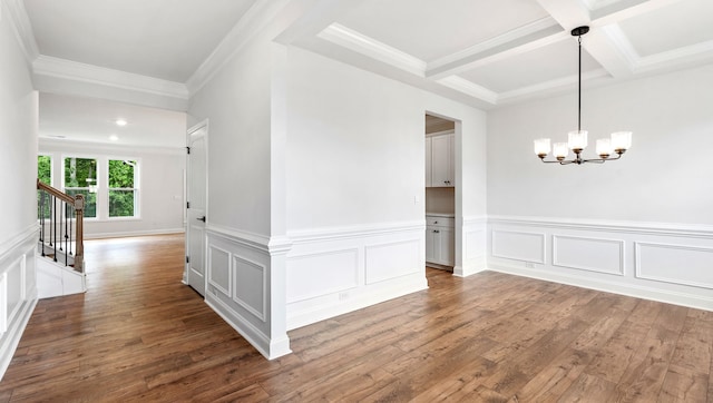 unfurnished room featuring coffered ceiling, beamed ceiling, an inviting chandelier, hardwood / wood-style flooring, and ornamental molding