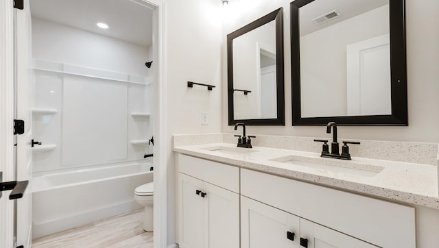 full bathroom with shower / bathing tub combination, wood-type flooring, vanity, and toilet