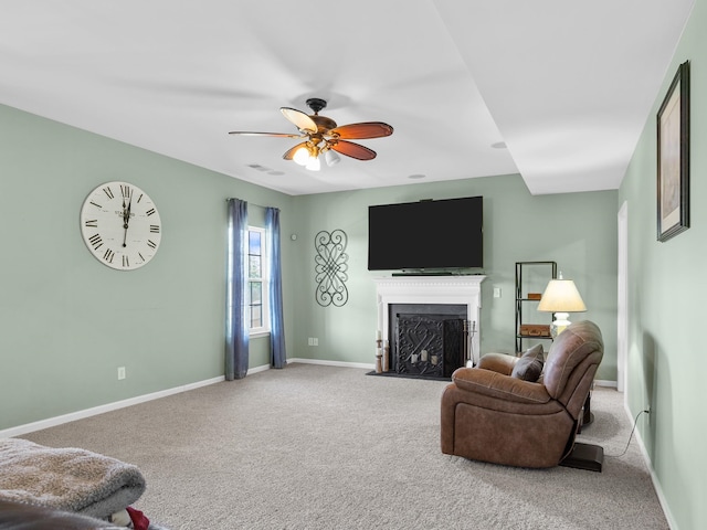 living room featuring carpet, ceiling fan, and a fireplace