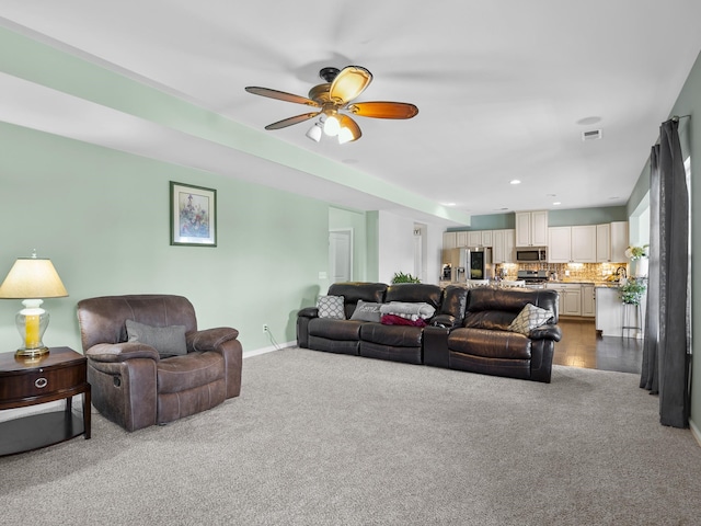 carpeted living room with ceiling fan