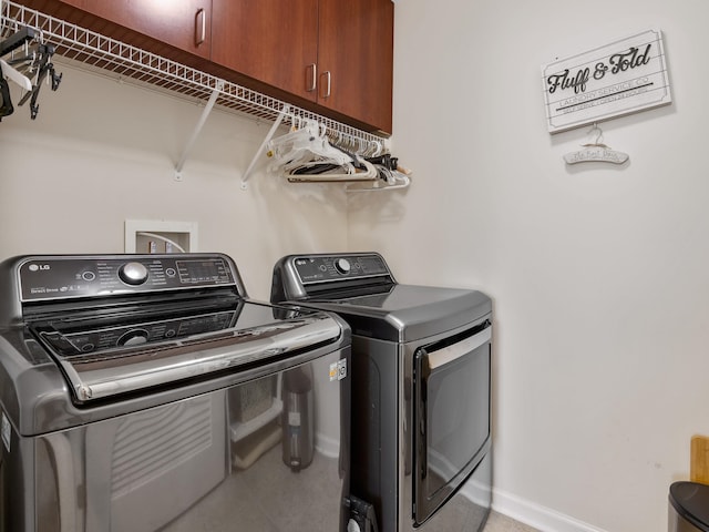 laundry area with cabinets, washing machine and dryer, and washer hookup