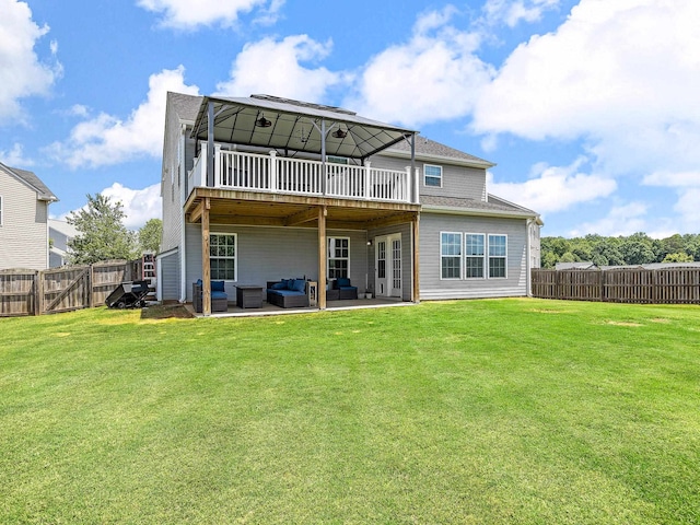 rear view of property with outdoor lounge area, a lawn, and a patio area