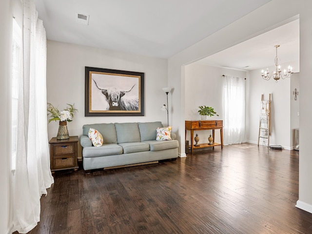 living room featuring dark hardwood / wood-style floors and an inviting chandelier