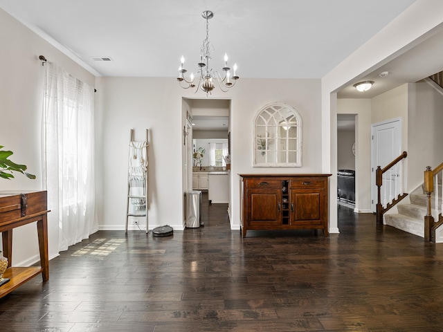 interior space featuring dark hardwood / wood-style floors and an inviting chandelier