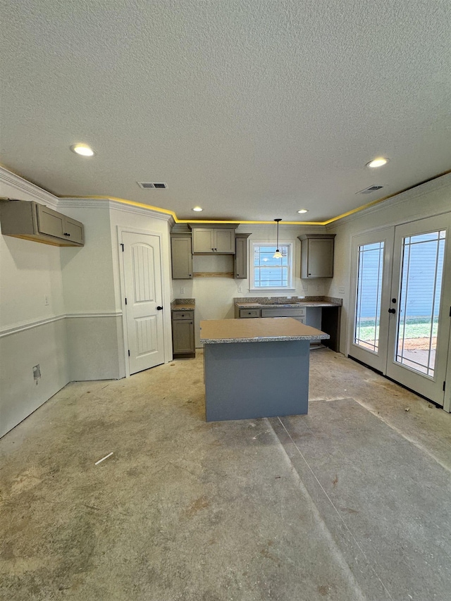 kitchen with decorative light fixtures, gray cabinetry, a center island, crown molding, and a textured ceiling