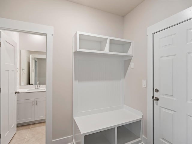 mudroom with light tile patterned floors and sink