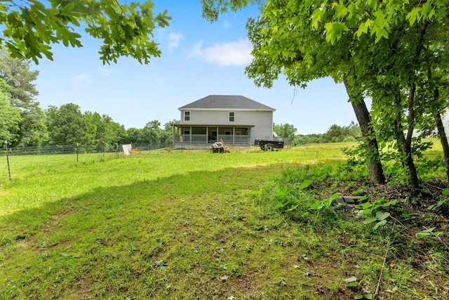 view of yard with a sunroom and a rural view