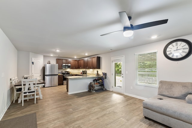 living room with ceiling fan and light wood-type flooring