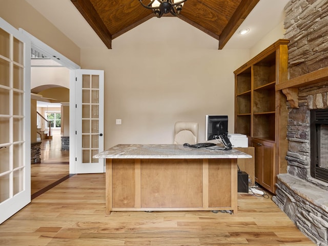 unfurnished office featuring a fireplace, french doors, wooden ceiling, and light hardwood / wood-style floors