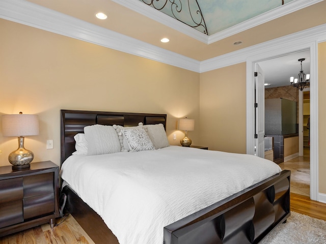 bedroom featuring an inviting chandelier, ornamental molding, and light hardwood / wood-style flooring