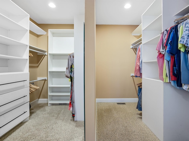 walk in closet featuring light colored carpet