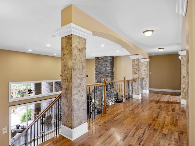 hall with wood-type flooring and ornate columns