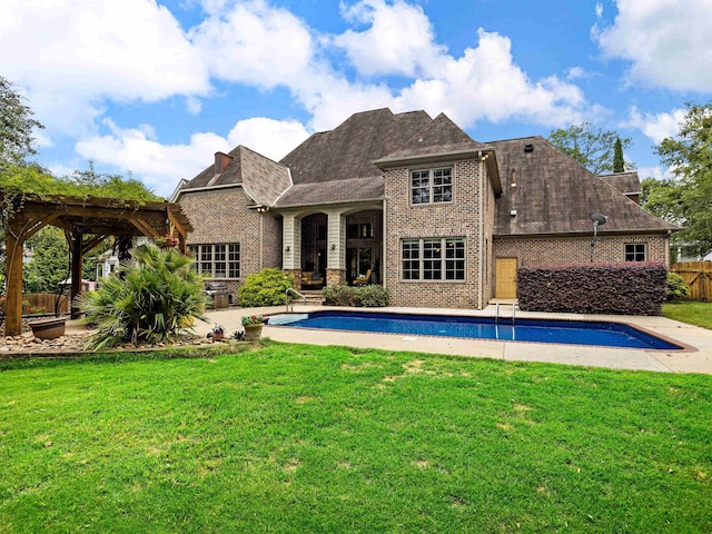 back of property with a pergola, a patio, and a lawn