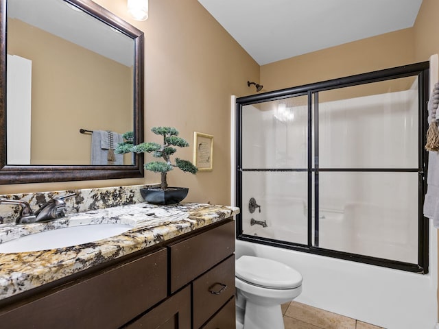 full bathroom featuring shower / bath combination with glass door, vanity, tile patterned floors, and toilet