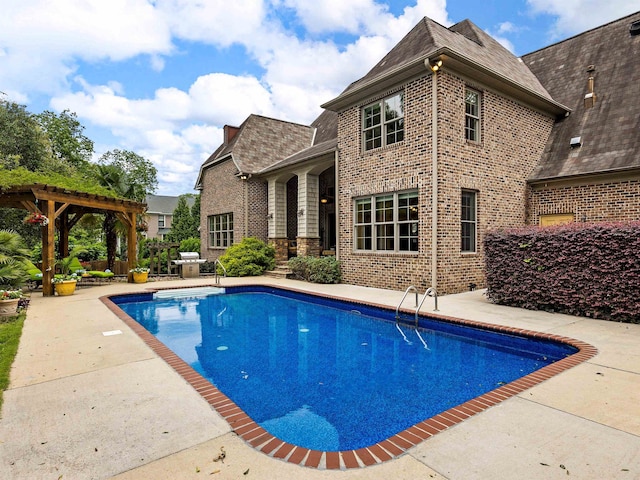 view of swimming pool with a grill, a patio area, and a pergola