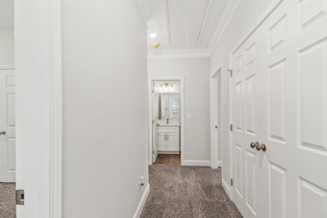 hall with dark colored carpet and crown molding