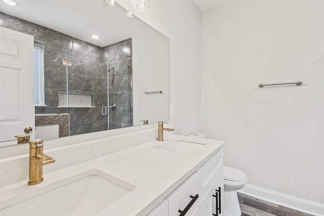 bathroom with dual bowl vanity, walk in shower, toilet, and hardwood / wood-style flooring