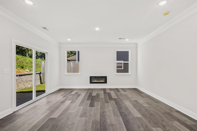 spare room featuring plenty of natural light, ornamental molding, and hardwood / wood-style floors