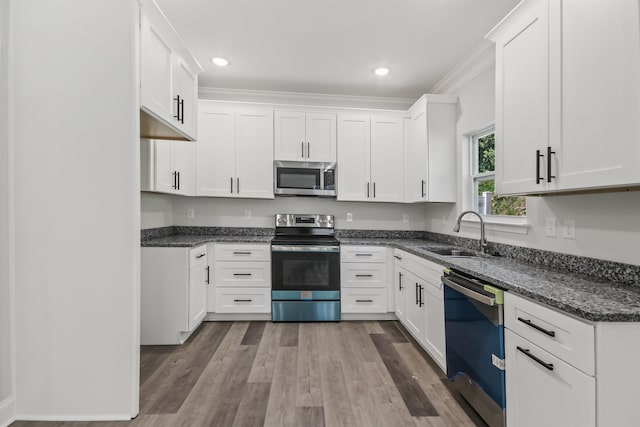 kitchen featuring stainless steel appliances, crown molding, sink, and wood-type flooring