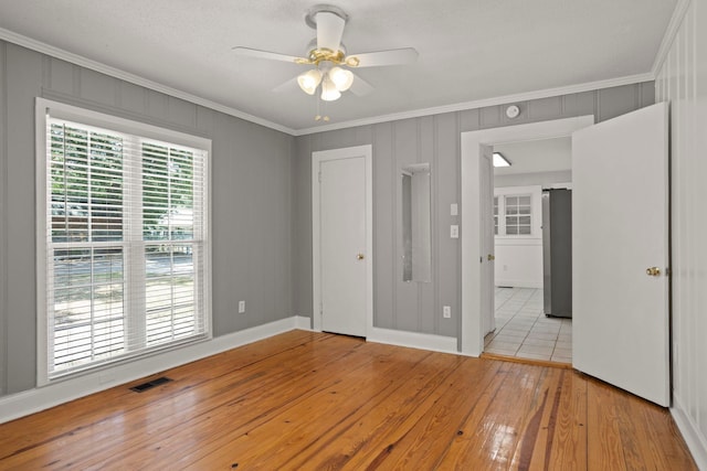 unfurnished room with a textured ceiling, light hardwood / wood-style flooring, ceiling fan, and ornamental molding