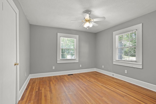 unfurnished room featuring ceiling fan, hardwood / wood-style floors, and a textured ceiling