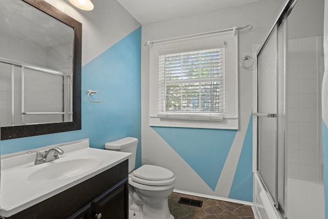 full bathroom featuring tile patterned flooring, vanity, toilet, and shower / bath combination with glass door