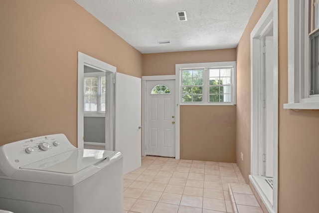 laundry area featuring washer / dryer, a textured ceiling, and light tile patterned floors