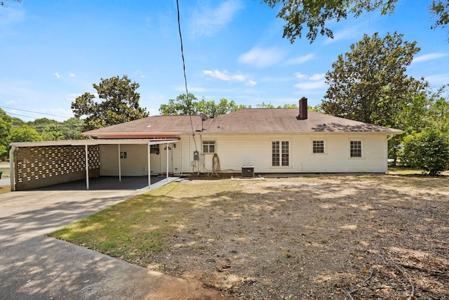 rear view of property with a carport and central AC