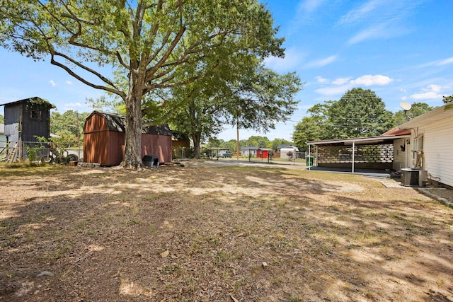 view of yard featuring an outbuilding, central AC, and a carport