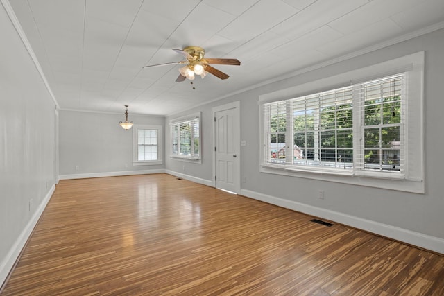 unfurnished living room featuring ceiling fan, wood-type flooring, and ornamental molding